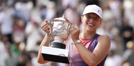 Poland's Iga Swiatek celebrates with the trophy as she won the women's final of the French Open tennis tournament against Italy's Jasmine Paolini at the Roland Garros stadium in Paris, France, Saturday, June 8, 2024. (AP Photo/Christophe Ena)