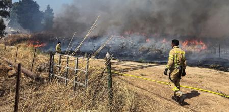 Bomberos israelíes en los incendios provocados por los cohetes