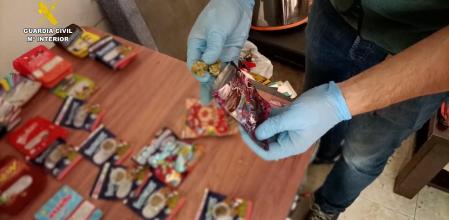 Un agente muestra el material envasado en bolsas de golosinas que contenían la droga.