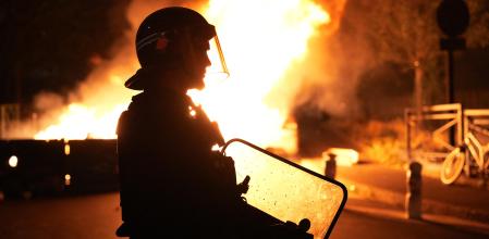 A firefighter looks on as vehicles burn following riots in Nanterre, west of Paris, on June 28, 2023, a day after a 17-year-old boy was shot in the chest by police at point-blank range in this western suburb of Paris. Violent protests broke out in France in the early hours of June 29, 2023, as anger grows over the police killing of a teenager, with security forces arresting 150 people in the chaos that saw balaclava-clad protesters burning cars and setting off fireworks. Nahel M., 17, was shot in the chest at point-blank range on June 27, 2023, morning in an incident that has reignited debate in France about police tactics long criticised by rights groups over the treatment of people in low-income suburbs, particularly ethnic minorities. (Photo by Zakaria ABDELKAFI / AFP)