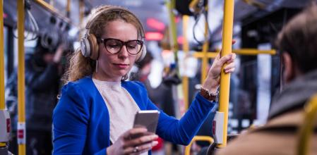 Una mujer de negocios escuchando música en el transporte público