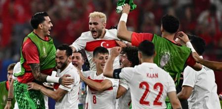 Turkey's players celebrate qualifying for the knock-out stages at the end of the UEFA Euro 2024 Group F football match between the Czech Republic and Turkey at the Volksparkstadion in Hamburg on June 26, 2024. (Photo by GABRIEL BOUYS / AFP)