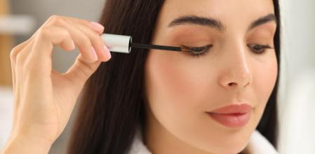 Una mujer se aplica el sérum crece pestañas.