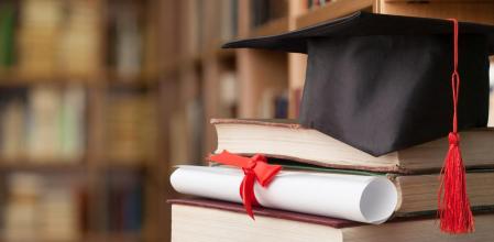 Libros y gorro de graduación.