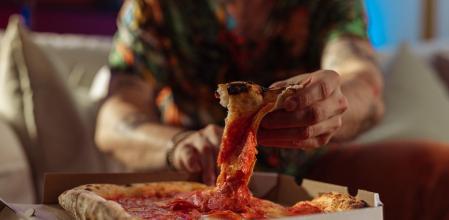 Hombre comiendo pizza