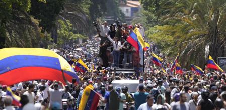Opposition leader Maria Corina Machado waves a national flag as she waves to supporters during a rally in Caracas, Venezuela, Saturday, Aug. 3, 2024. (AP Photo/Matias Delacroix)