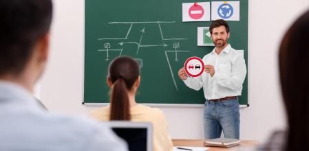 Alumnos de una autoescuela atienden a las explicaciones del profesor 