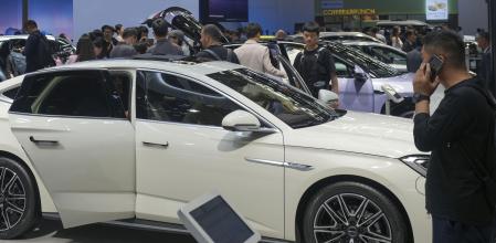 FILE - Visitors look at cars at the BYD booth during the China Auto Show in Beijing, China, Friday, April 26, 2024. The European Union threatened on Wednesday, june 12, 2024, to hike tariffs on Chinese electric vehicles, escalating a trade dispute over Beijing's subsidies for the exports that Brussels worries is hurting domestic automakers. (AP Photo/Tatan Syuflana, File)