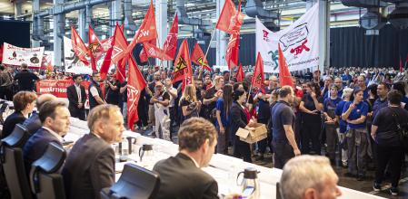 Employees protest before the start of a works meeting in a hall at the VW plant in Wolfsburg, Wednesday, Sept. 4, 2024. Volkswagen has announced that it will tighten its austerity measures due to the tense situation of the core brand. Redundancies and plant closures can no longer be ruled out. (Moritz Frankenberg/pool photo via AP)