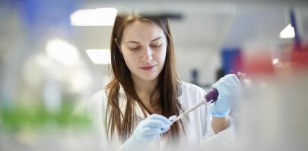 Una investigadora biomédica, con una pipeta en un laboratorio