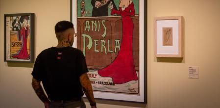 Un visitante contempla uno de los carteles diseñados por Eveli Torent