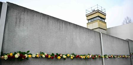 Flowers are placed at the Wall Memorial by guests during the central commemoration ceremony for the 35th anniversary of the fall of the Berlin Wall, on November 9, 2024 at the Berlin Wall Memorial at Bernauer Strasse in Berlin. Germany on Saturday celebrates 35 years since the fall of the Berlin Wall ushered in the end of communism and national reunification. (Photo by Tobias SCHWARZ / AFP)