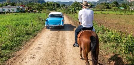 Un hombre pasea a lomos de un caballo por un camino de Vinales, en Cuba