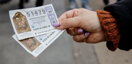 Una mujer sostiene dos décimos para el Sorteo Extraordinario del Niño, a 2 de enero de 2023, en Madrid (España). El Sorteo Extraordinario del Niño celebra su 80ª edición coincidiendo con el día de los Reyes Magos. La lotería del Niño reparte hasta 700 millones de euros en premios, con un primer premio de 2.000.000 de euros a la serie. A pesar de que en el Sorteo Extraordinario de la Lotería del Niño tocan más premios que en la Lotería de Navidad, la cantidad de estos premios es menor.