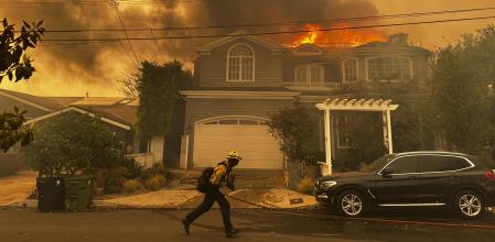 Una residencia arde mientras un bombero combate el incendio de Palisades en el barrio de Pacific Palisades de Los Ángeles el martes 7 de enero de 2025.&nbsp;