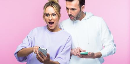 Una pareja sorprendida mirando el móvil