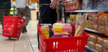 Una persona empuja una cesta de la compra en un supermercado 
