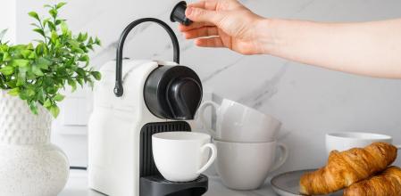 Una persona a punto de hacerse un café en una cafetera de cápsulas