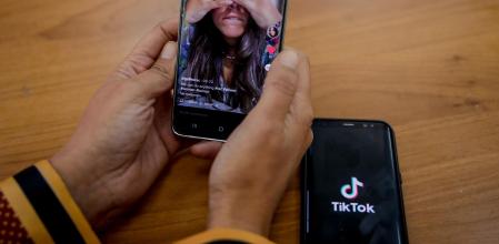 Una persona mira en su móvil el vídeo de una joven en la red musical Tik Tok, en Madrid (España), a 22 de septiembre de 2020. TikTok ha publicado este martes su tercer Informe de Transparencia, que recoge la actividad del primer semestre de 2020, en el que se eliminaron más de cien millones de vídeos por infringir las normas de la plataforma.