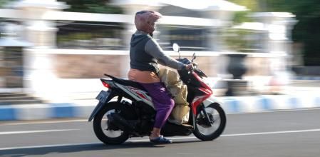 Una motorista lleva diversas bolsas sobre la plataforma del scooter que sirve para poner los pies