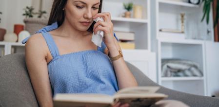 Una mujer llorando mientras lee un libro