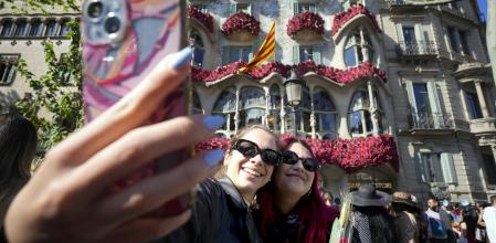 Dos jóvenes se fotografían ante la Casa Batlló, en el Paseo de Gracia de Barcelona, durante la Diada de Sant Jordi