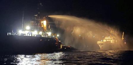 Un remolcador equipado con equipos contra incendios, a la izquierda, ayuda a controlar un incendio ocurrido en la proa del buque Conscience en aguas internacionales del Mediterráneo&nbsp;