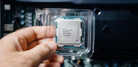 Vista frontal del ingeniero mano masculina sosteniendo nueva CPU Intel