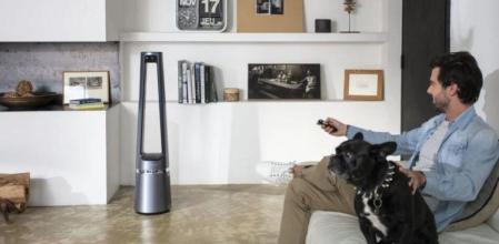 Un hombre con un perro manejando un ventilador sin aspas en su salón