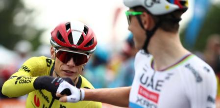 UAE Team Emirates' Slovenian rider Tadej Pogacar (R) fist bumps with Team Visma-Lease a Bike's Danish rider Jonas Vingegaard prior to the start of the 1st stage of the 77th edition of the Criterium du Dauphine cycling race, 195,8 km between Domérat and Montlucon, on June 8, 2025. (Photo by Anne-Christine POUJOULAT / AFP)