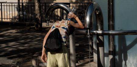Un joven se pasa agua por la cabeza en el Distrito 13 de París.&nbsp;
