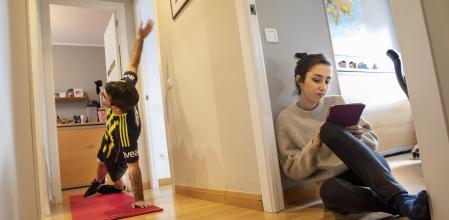 Un adolescente practica ejercicio mientras su hermana utiliza una tableta electrónica 