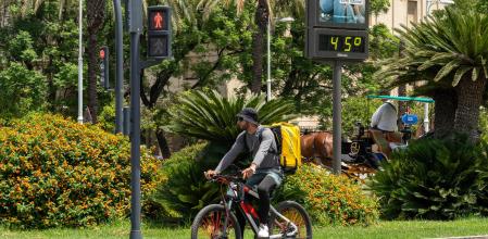 Un termómetro marca 45 grados a las 14:00 de la tarde junto a un trabajador de Glovo en bicicleta, a 19 de julio de 2024, en Sevilla.&nbsp;