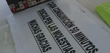 Imagen del cartel pegado en una de las mesas del bar, en el que se informa a los clientes que tienen 50 minutos por cada consumición que hagan en el local
