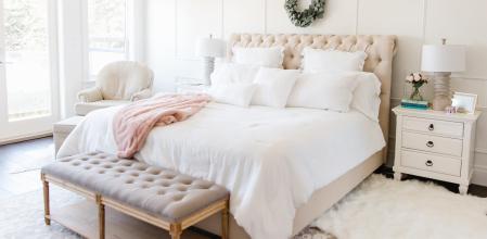 Dormitorio en tonos claros con cabecero tapizado con capitoné