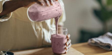 Una mujer sirviéndose un smoothie.