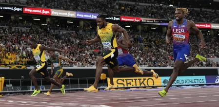 Jamaica's Oblique Seville, left, finishes ahead of Jamaica's Kishane Thompson, center, and United States' Noah Lyles to win the men's 100 meters final at the World Athletics Championships in Tokyo, Sunday, Sept. 14, 2025. (AP Photo/David J. Phillip)