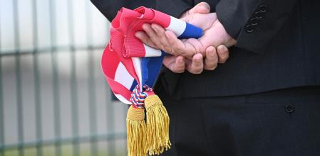 Un oficial sostiene una banda con la bandera francesa&nbsp;