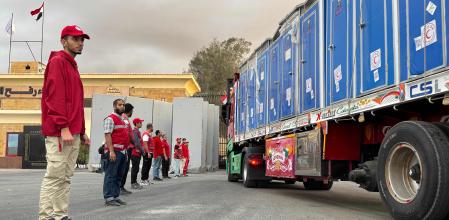 Members of the Red Crescent stand near a truck loaded with humanitarian aid on the Egyptian side of the Rafah crossing, waiting to get access to the Gaza Strip, on October 12, 2025. International agencies are waiting to pour aid into Gaza, hopeful a US-brokered ceasefire between Israel and Hamas will allow them to put an end to the famine haunting parts of the territory. The fragile truce could open access, but aid agencies fear Israel may continue to impose restrictions on access under US President Donald Trump's plan. (Photo by AFP)