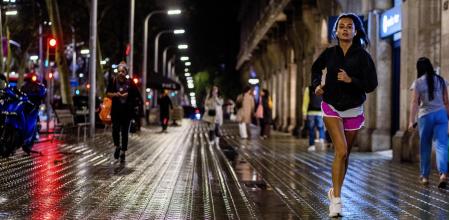 Una joven por la iluminada acera de la Diagonal 