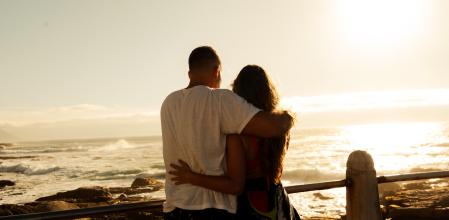 Pareja en la playa
The setting appears to be an outdoor coastal or rocky beach area, with sunlight filtering through the woman's hair, creating a dreamy, backlit effect. The golden hour lighting enhances the romantic and carefree atmosphere, evoking themes of love, relaxation, and living in the moment. The candid nature of their body language suggests a spontaneous, joyful interaction, making this image ideal for themes related to romance, happiness, summer vacations, and meaningful connections.