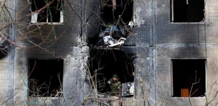 An investigator looks through the window of an apartment building damaged during an overnight Russian drone and missile strike, amid Russia's attack on Ukraine, in Kyiv, Ukraine, November 14, 2025. REUTERS/Thomas Peter TPX IMAGES OF THE DAY