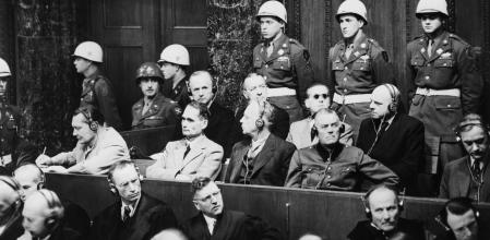 Los nazis acusados, sentados en sendas filas de banquillos en la sala 600 del palacio de Justicia de Nuremberg; entre ellos, Hermann Göring tomando notas. Delante, sus abogados defensores<br>