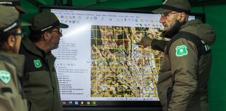 Agentes rurales sobre el terreno consultan un mapa de la zona afectada 