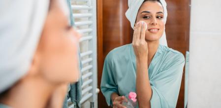 Mujer aplicándose agua micelar