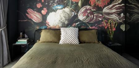 El protagonista en el dormitorio es un mural con enormes flores que recuerda a la pintura flamenca