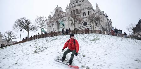 Un snowboarder esquía en el jardín de la Plaza Louise Michel, con Basílica del Sagrado Corazón de Montmartre (París) al fondo&nbsp;