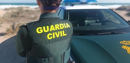 Agente de la Guardia Civil junto a vehículo