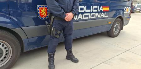 Un coche y un agente de la Policía Nacional.