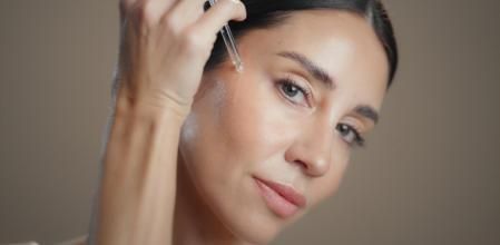 Una mujer poniéndose sérum en el rostro